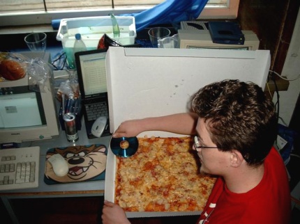[Photo: D-force cutting pizza with a CD-R]