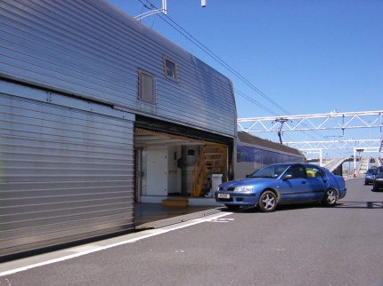 [Photo: Car driving onto train]